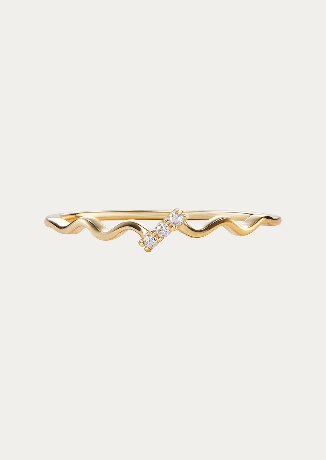A gold wavy ring adorned with three cubic zirconia gems attached in a slanted fashion.