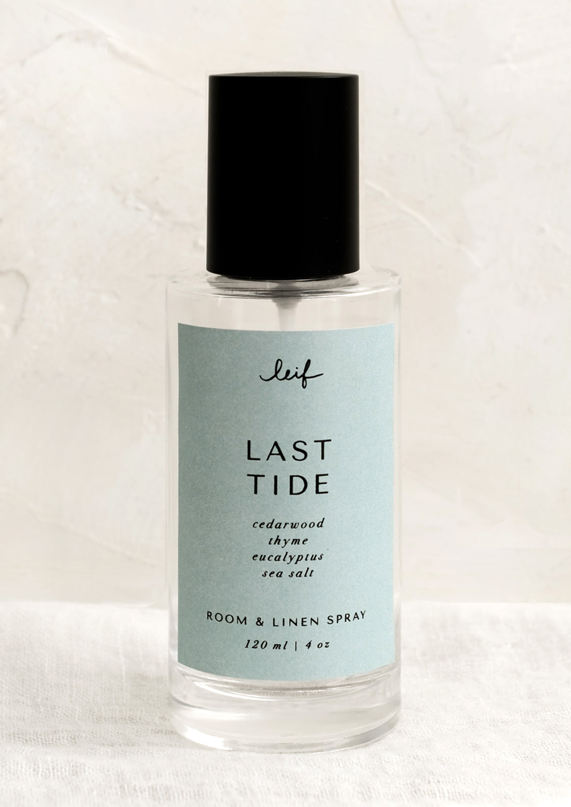 A room spray bottle with printed text on blue label.