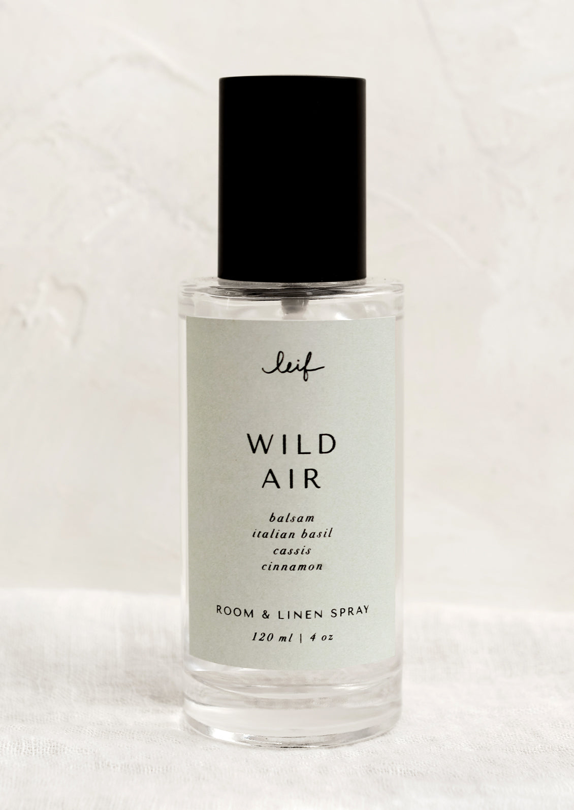 A room spray bottle with printed text on seafoam label.