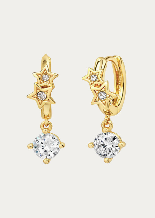 A pair of gold huggie earrings with stars and dangling crystal gems.