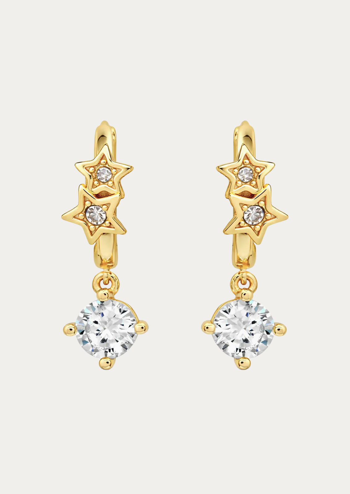 A pair of gold huggie earrings with stars and dangling crystal gems.