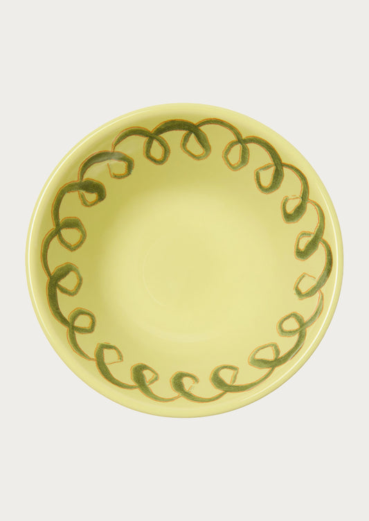 A greenish yellow bowl with a squiggle design along the edge.