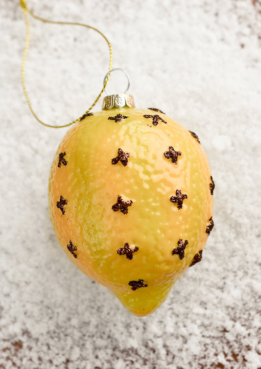 A glass ornament of a clove spiked lemon.