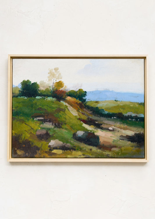 An original landscape oil painting in bright green and blue tones of a hillside in the country.