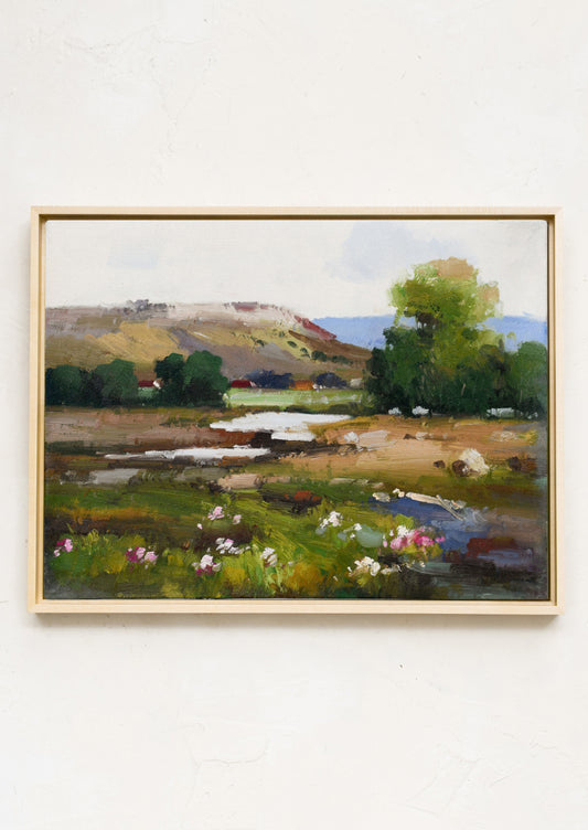 A framed original landscape oil painting of a colorful country meadow.