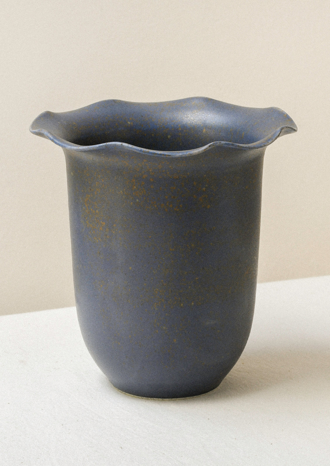 A charcoal grey ceramic speckled vase with a rippled lip design.