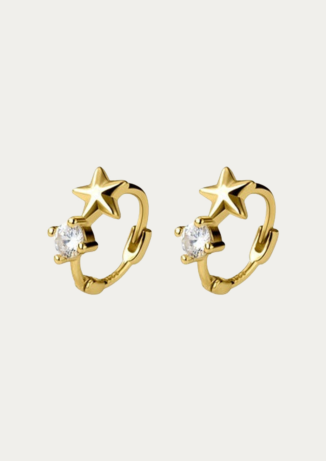 A pair of gold huggie hoop earrings with a star and a cubic zirconia gem.