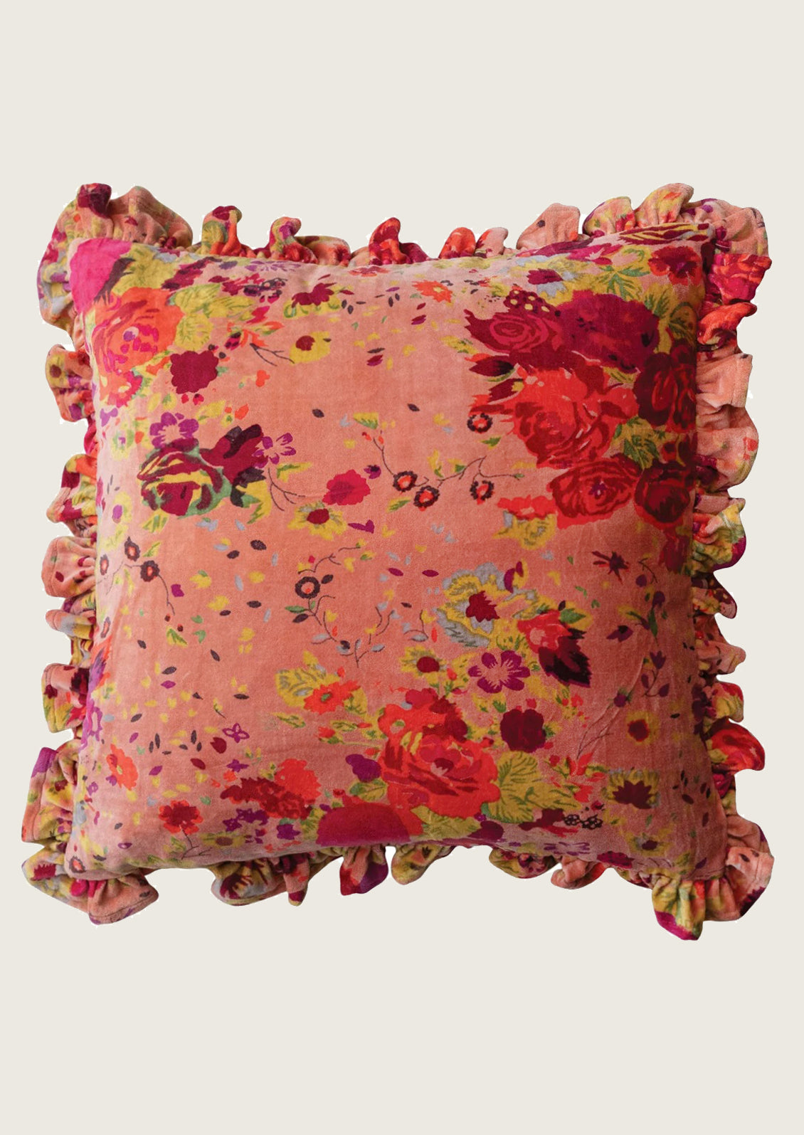 A square decorative throw pillow with a vibrant floral print in shades of pink, red, and green, finished with a ruffled fabric border, shown against a plain light beige background.