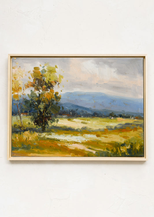 An original landscape oil painting of a field against mountainous backdrop.