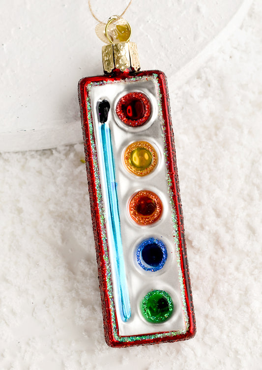 A glass holiday ornament of small watercolor pan.