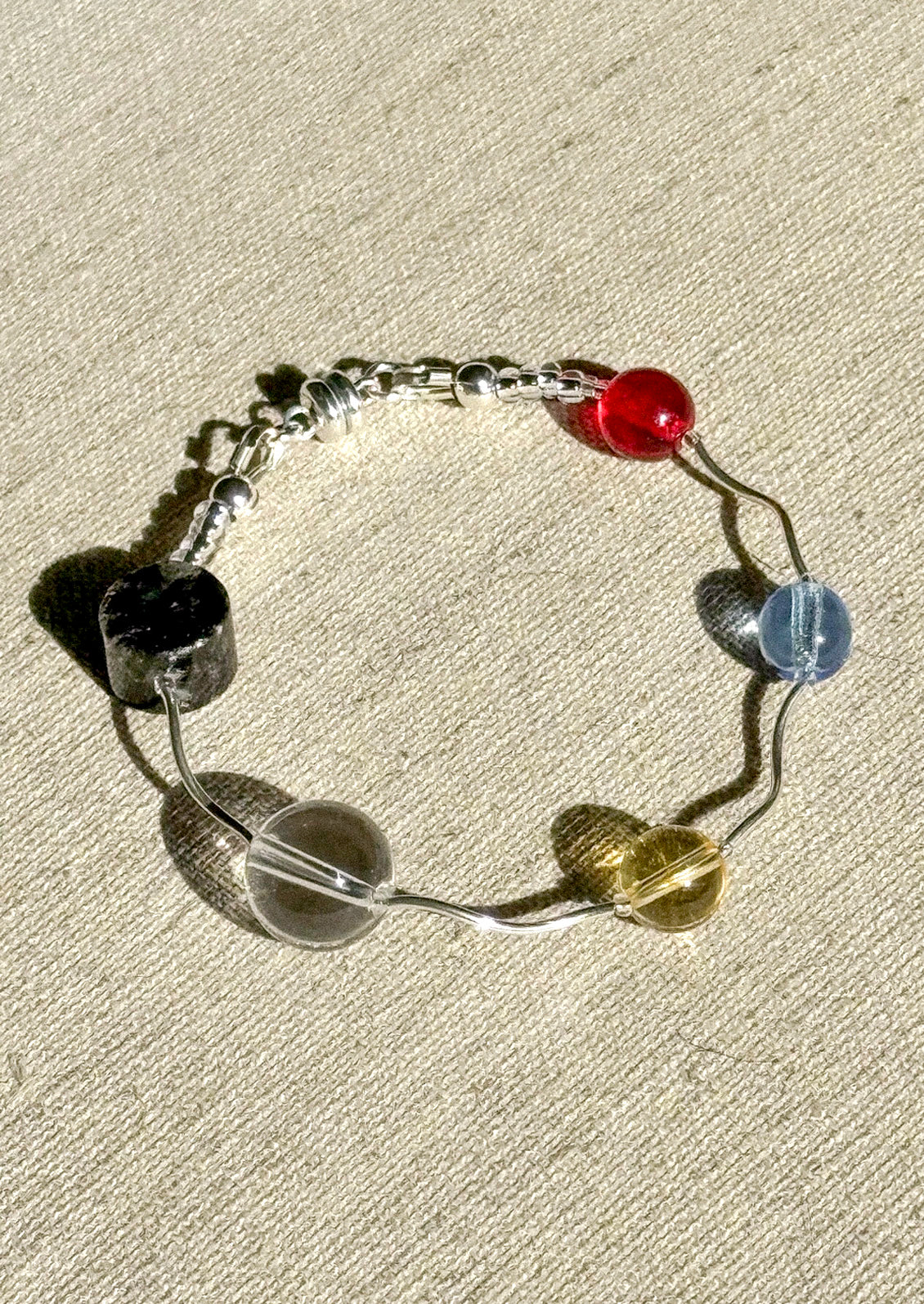 A sterling silver bracelet with a variety of different beads.