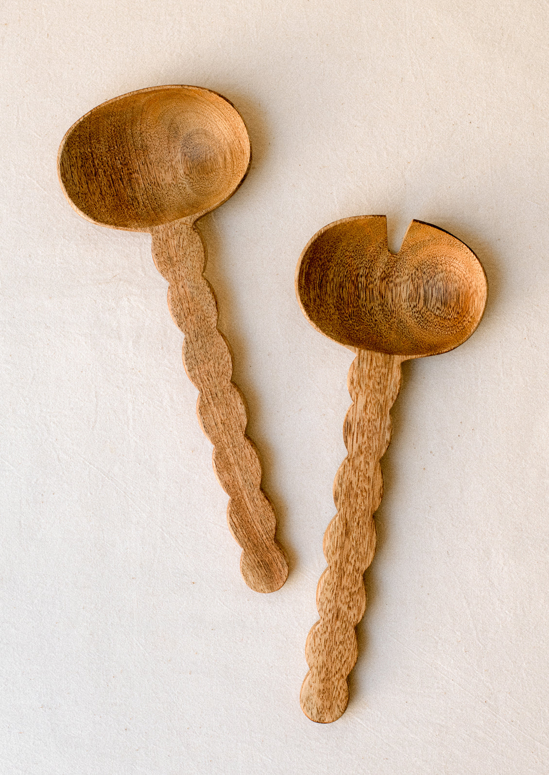 Mango wood salad serving set with wavy/scalloped handle.