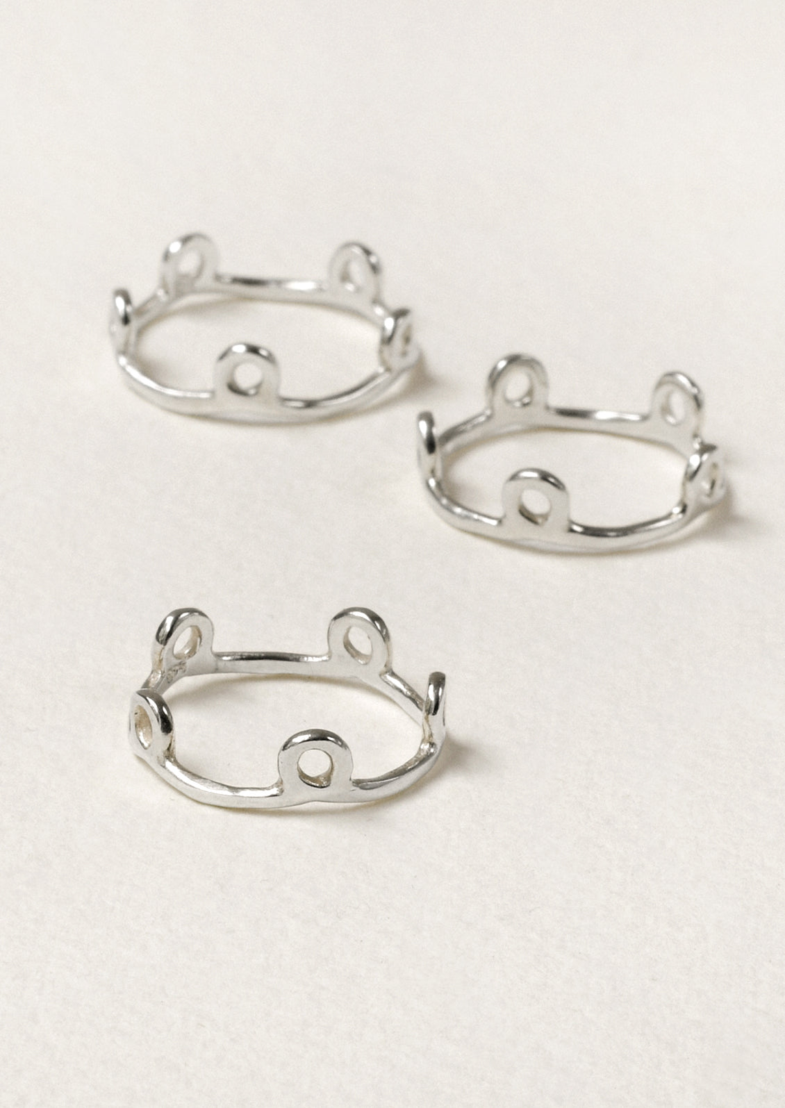 Three sterling silver rings with small circles along the band.