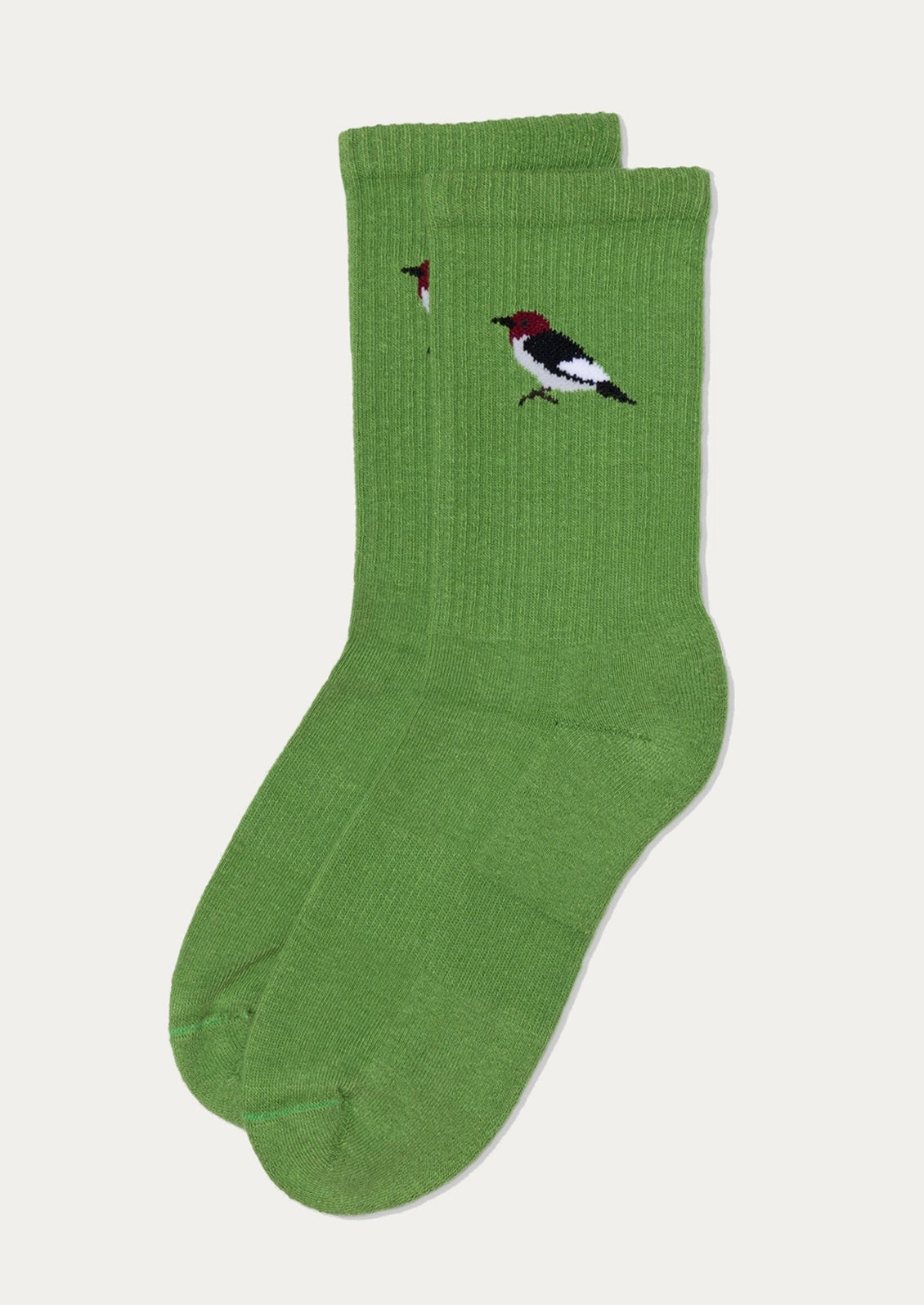 A pair of green crew socks with embroidered bird motifs on the upper calf, displayed against a light gray background.