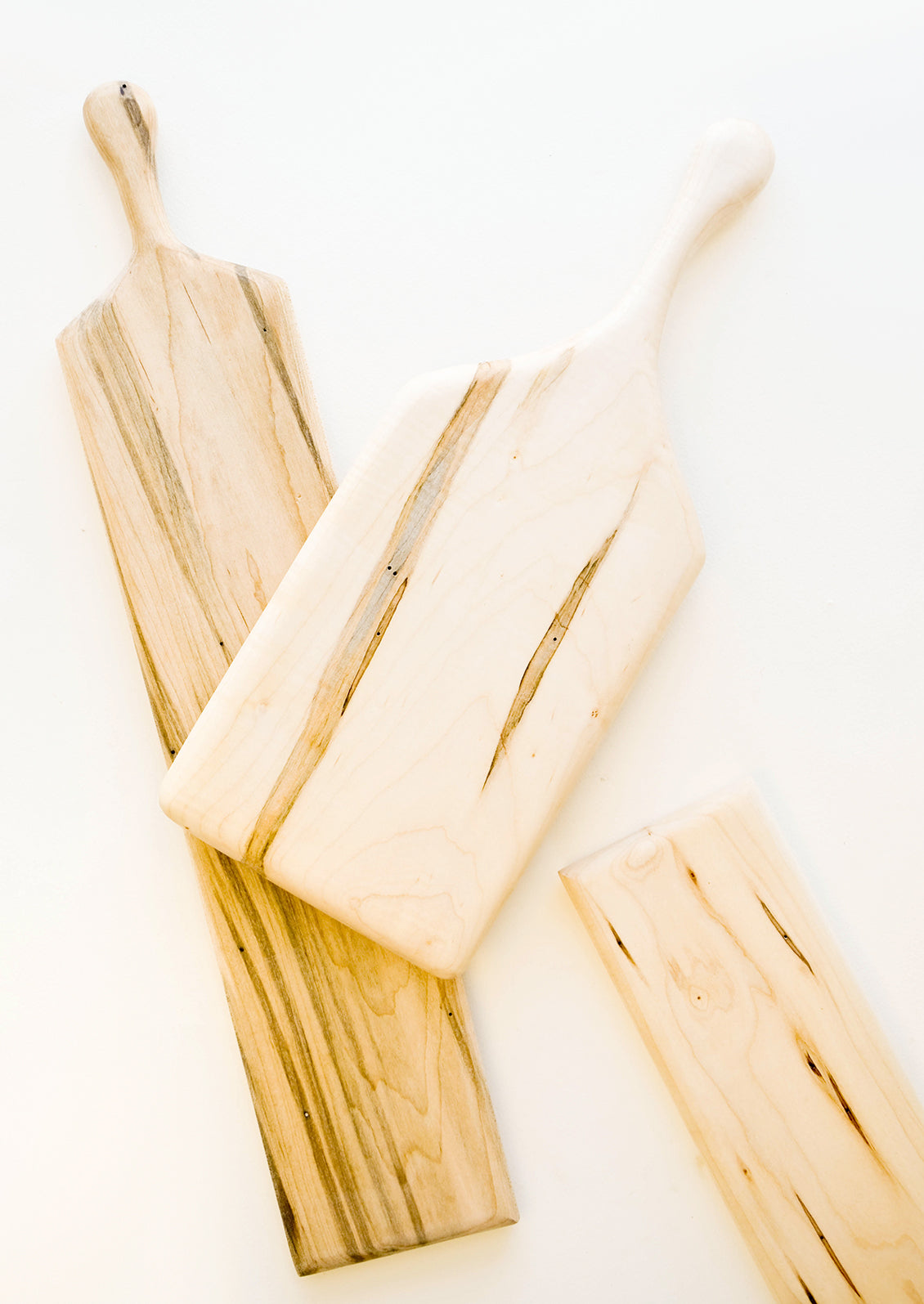 Three pale wooden rectangular cutting boards.