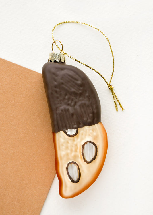 A glass holiday ornament designed to look like a piece of chocolate dipped biscotti.