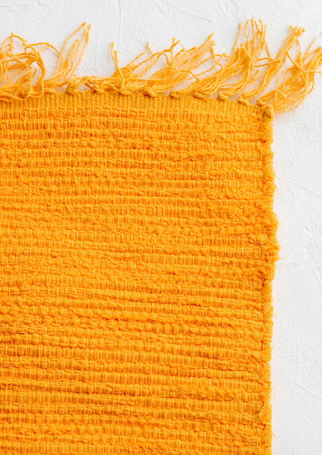 A textured cotton rug in mango orange.
