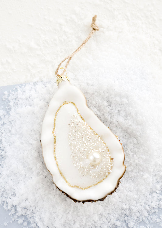 A holiday ornament designed to look like an oyster on the half shell with a pearl.