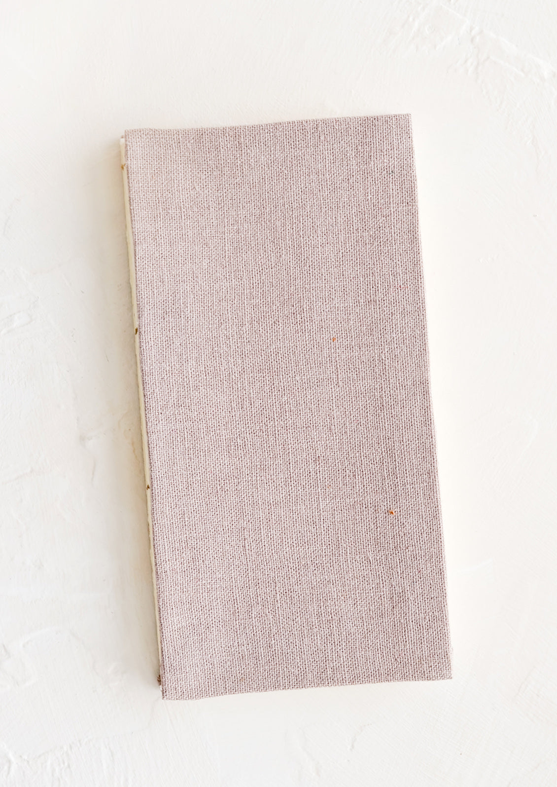 A cloth-covered notebook in naturally dyed mauve hue.