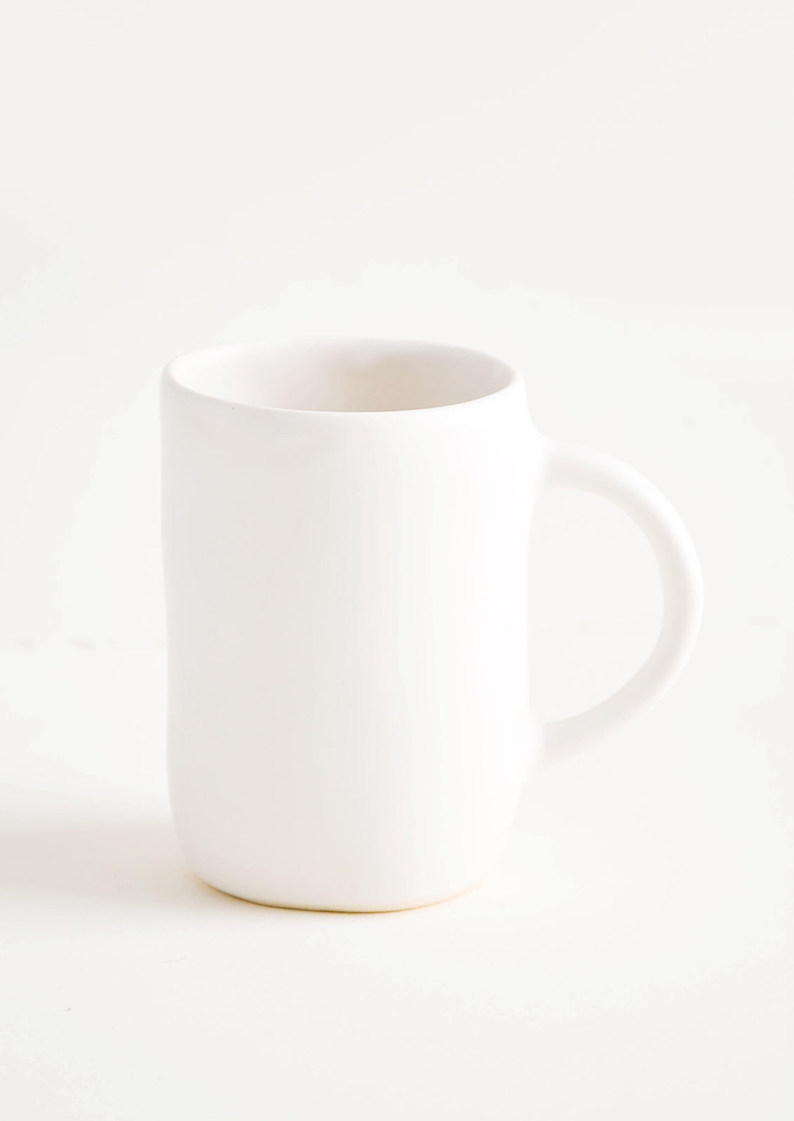Ceramic mug with handle in matte white glaze.