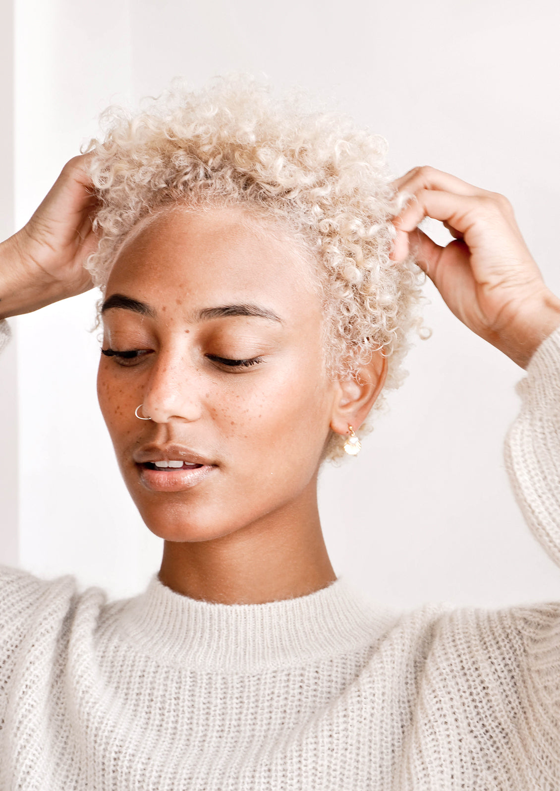 Model shot showing woman wearing earrings and white sweater.
