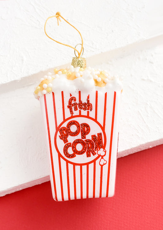 A glass ornament in shape of popcorn bag.