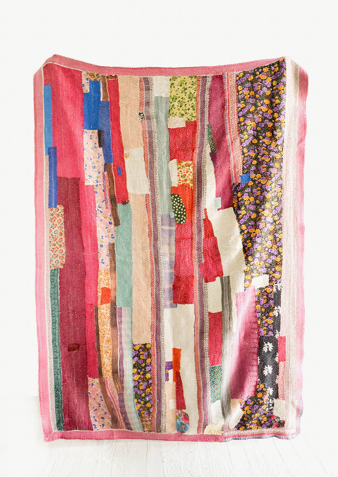 Vintage patchwork quilt in a mix of colors and fabrics. Predominantly magenta, brown and ivory.